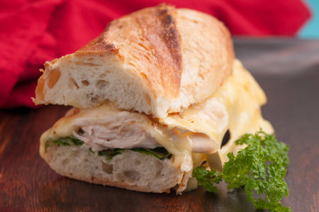 brie melted on chicken on a baguette bread rollの写真素材