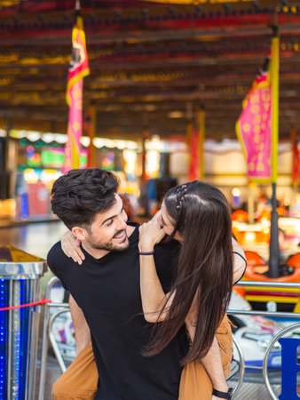 A young caucasian male carrying his girlfriend on his back during a date at an amusement parkの写真素材