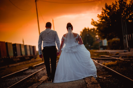 A beautiful shot of happy newlyweds walking down the street during the sunsetの写真素材