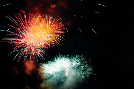 A low angle shot of colorful fireworks at night - great for wallpapers and backgroundsの写真素材