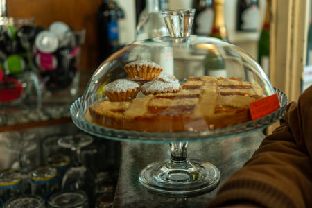A closeup shot of fresh cupcakes and other pastries in a glass tray at a cafeの写真素材