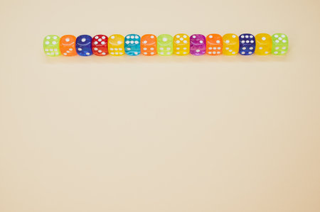 Colorful dice in a row isolated on a beige background