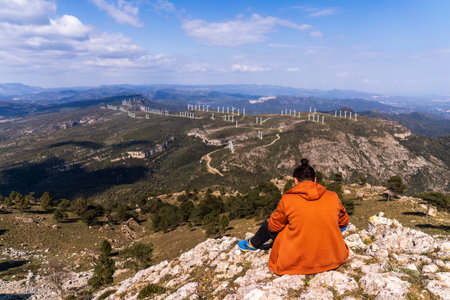 A person sitting on top of a mountain with a beautiful view of Llaberia