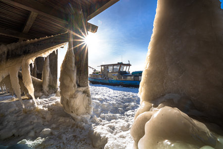 A beautiful shot of an icy frozen shore of the lake during frosty wintertime.の写真素材