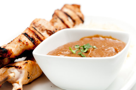 grilled chicken on bamboo skewers with a peanut dipping sauceの写真素材