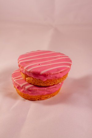 A vertical shot of pink cookies on a white background