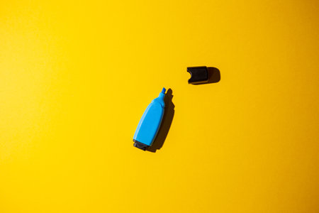 A top view of a blue marker on a yellow work tableの写真素材