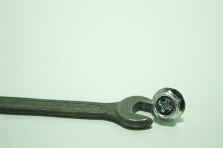 A closeup shot of a bolts with a spanner on a white background