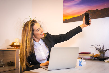 A Spanish woman doing a selfie during her work near her desk