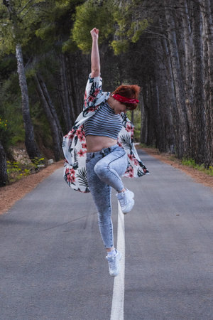 A vertical shot of a Caucasian female jumping happily on the