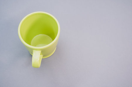 An empty green plastic cup isolated on a grey backgroundの写真素材
