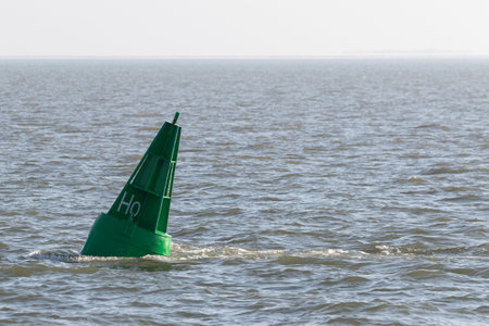 Green conical buoy floats in the North Sea off Hallig Hooge.の写真素材