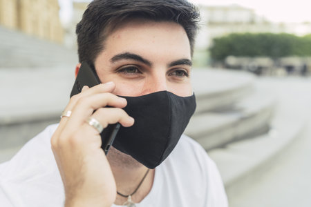 A Spanish man in a mask talking on the phone