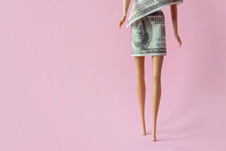 Legs of a doll, dressed in dollar bill; Consumerism, fashion, shopaholic; Creative background with copy spaceの写真素材