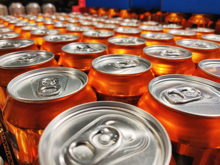 A selective focus shot of shiny orange cans production line at a factoryの写真素材