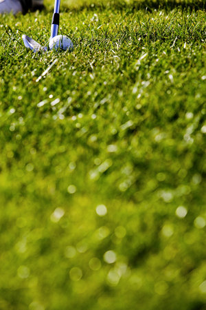 A selective focus of a ball and club on green fields in a golf courseの写真素材