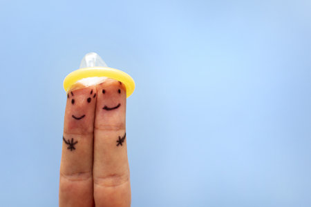 Two fingers under condom. Safe sex concept. Prevention against sexually transmitted diseases, AIDS.の写真素材