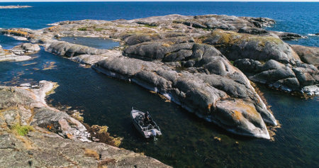 Boat driving in between, rocky klovarskar island, sunny summer day, in the finnish archipelago of saaristomeri national park, Varsinais-suomi, Finlandの写真素材