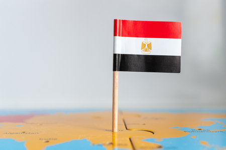 A small flag of Egypt on a wooden stick fixed on the globeの写真素材