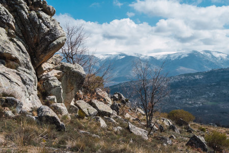 A beautiful landscape of rocky slope with mountains and clouds in the backgroundの写真素材