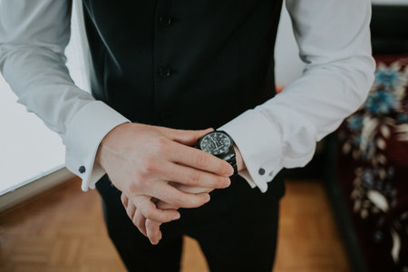 The unrecognizable groom with the clock on the hand
