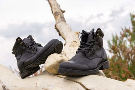 men's boots, black leather with river and trees in the backgroundの写真素材