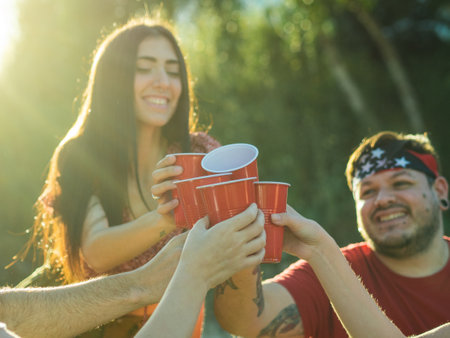 A group of young people clinking plastic red cups at a partyの写真素材