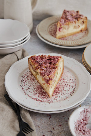A closeup shot of delicious rhubarb cheese pie on a plate on a white tableの写真素材