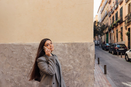 A beautiful Caucasian female talking on the phone while walking outdoors