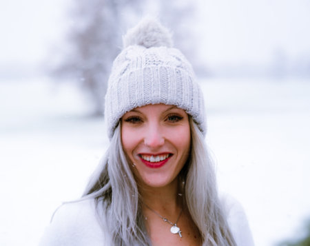 A young Caucasian girl wearing a hat and face piercings on a snowy dayの写真素材