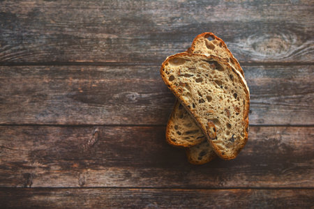 Flat lay of three slices of sourdough bread stuffed with greaves lying on wooden table.の写真素材