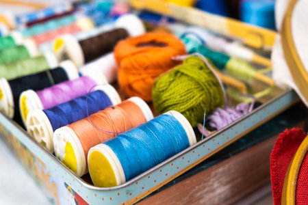 A closeup of the sewing colorful threads in the metal container