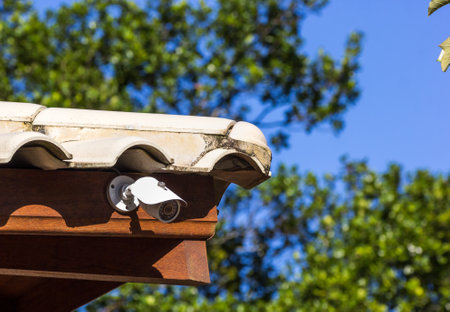 A closeup shot of a surveillance camera on the roofの写真素材