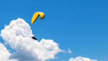 A person parasailing in the cloudy skyの写真素材