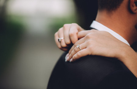 A shallow focus shot of the bride hugging her groom on the wedding dayの写真素材