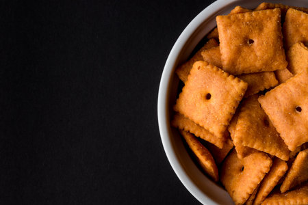 A top view of crackers in the bowl in black background with copy spaceの写真素材