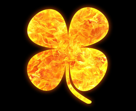 A four-leaved clover outline with a bright fire pattern isolated on a black backgroundの写真素材
