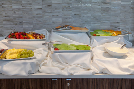 A buffet with a white tablecloth and fresh delicious fruitsの写真素材
