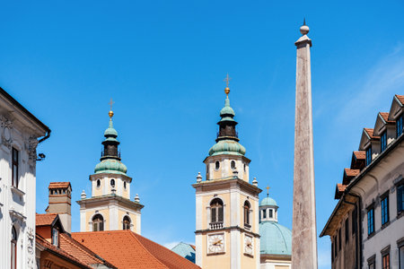 Low angle view of beautiful church towers of St. Nicholas cathedral and Robba fountain obelisk in Ljubljana, Slovenia.の写真素材