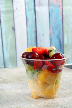 A selective focus shot of fresh fruit salad in a plastic cupの写真素材