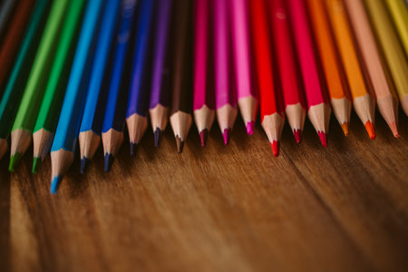Colored pencils on wooden background with selective focus. Back to school and education concept. Crayons background for designの写真素材