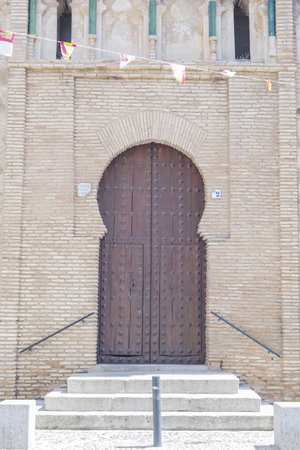 a vertical shot of a huge brown door with three stairs in Toledo Spainの写真素材