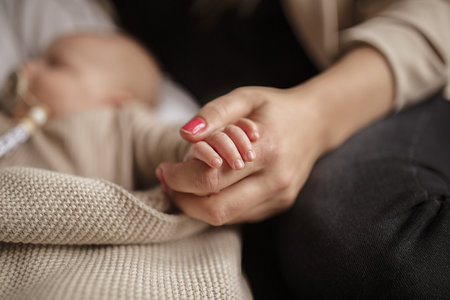 A woman holding her newborn baby's handの写真素材