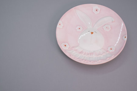 A plate with Easter bunny decoration isolated on purple backgroundの写真素材