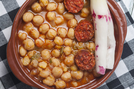 A closeup shot of chickpea stew with chorizo and radish in a hot potの写真素材