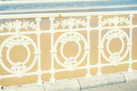 A closeup of the beautiful metallic fence on the bridge on the Beach of La Concha in Spainの写真素材