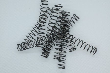 A top-view shot of many springs on each other in a plain background.