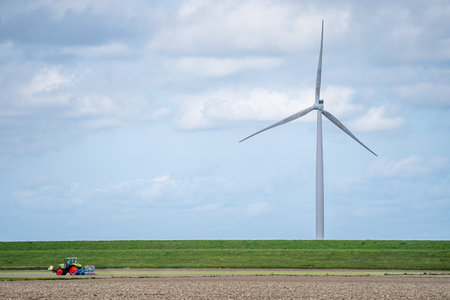 Wind turbines in a field under a cloudy skyの写真素材