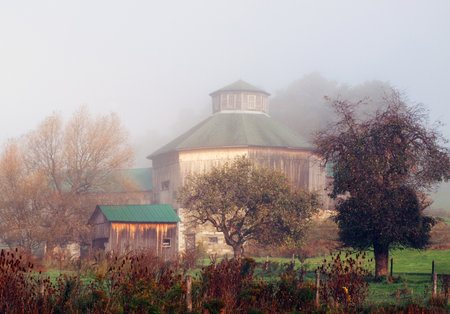 octagon barn on a foggy autumn morningの写真素材
