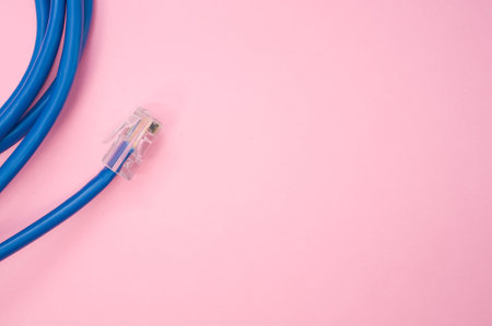 A top view of a blue LAN cable isolated on a pink backgroundの写真素材